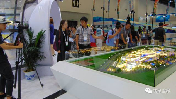 李子欣李總通過沙盤模型向記者介紹際華園冰雪體育運動小鎮的未來發展規劃