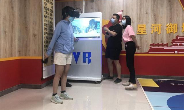 社區居民王女士則在VR滑雪體驗區體驗瞭驚險刺激的滑雪項目