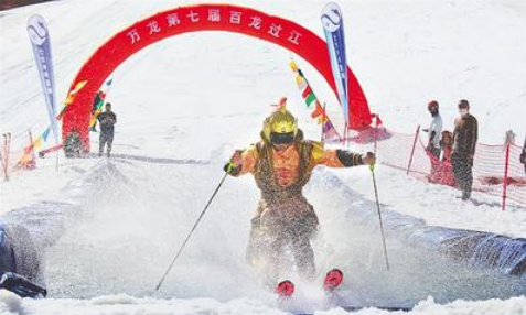 5月1日，萬龍滑雪場第七屆“百龍過江”活動現場，一名選手滑過水池。