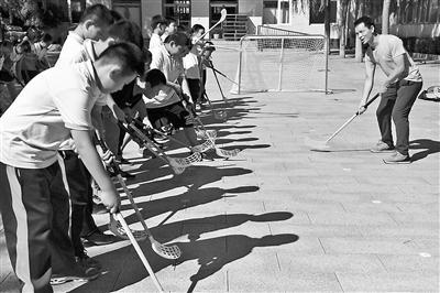 同學們在教練的指導下擺動球杆進行撥球練習