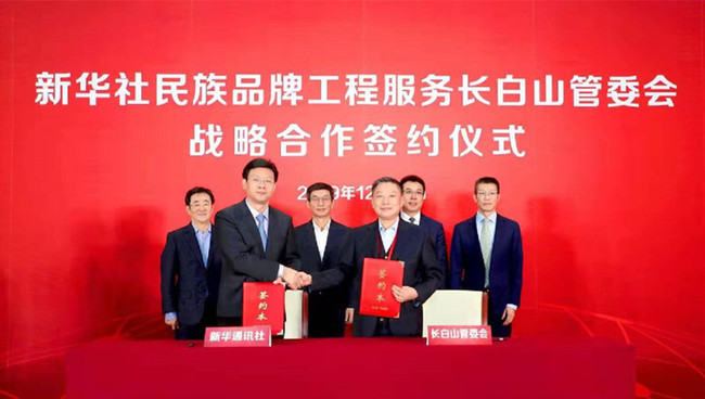 新華社新聞信息中心主任儲學軍（前左）與長白山黨工委委員、管委會副主任王鵬飛（前右）代表雙方簽署戰略合作協議。